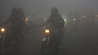 Sejumlah pengendara melaju dengan menyalakan lampu depan saat kabut tebal menyelimuti Lahore, Pakistan, Rabu (15/12/2021) waktu setempat.  