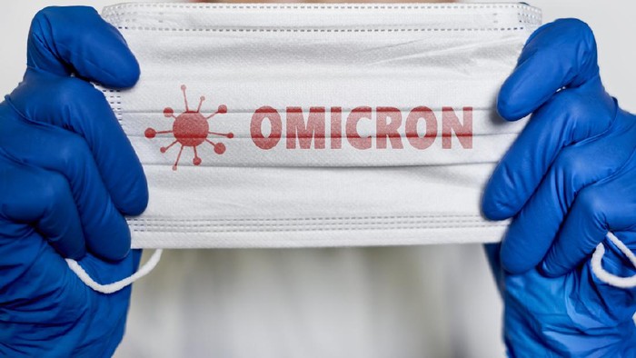 Female doctor holds a face mask with - Omicron variant text on it. Covid-19 new variant - Omicron. Omicron variant of coronavirus. SARS-CoV-2 variant of concern