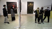 Pengunjung melihat-lihat karya seni yang dipamerkan.