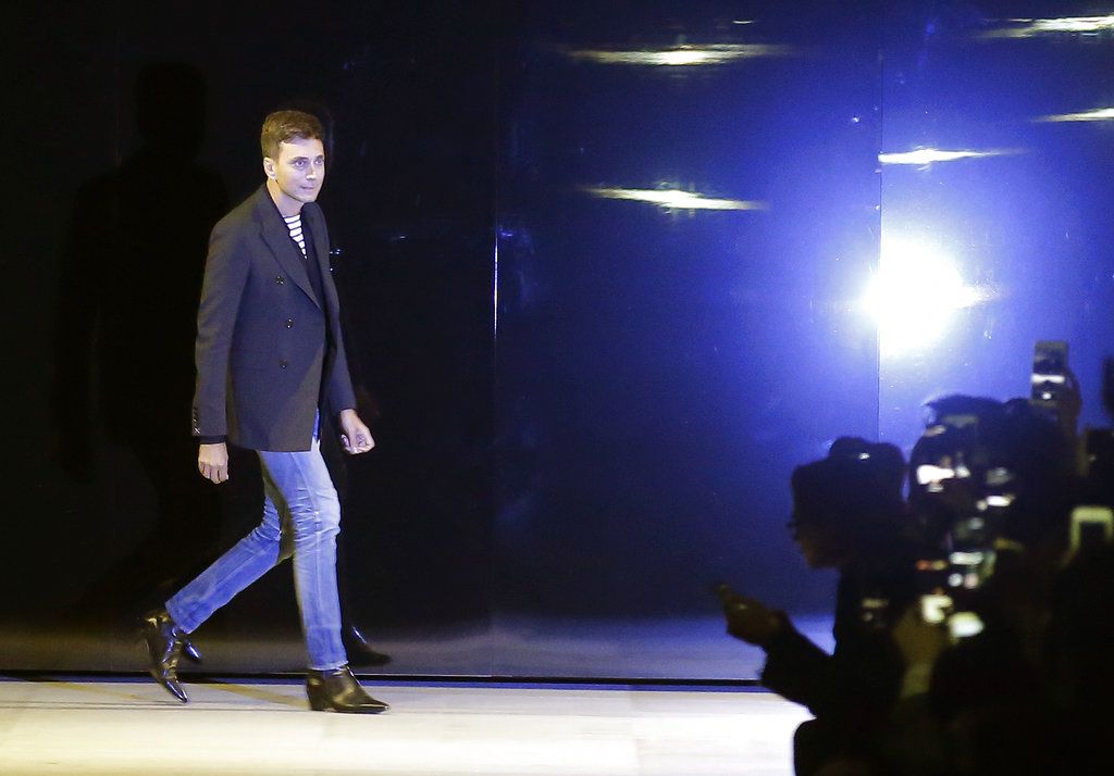 Designer Hedi Slimane accepts applause at the end of the Celine Spring/Summer 2019 ready to wear fashion collection presented in Paris, Friday, Sept. 28, 2018. (AP Photo/Michel Euler)