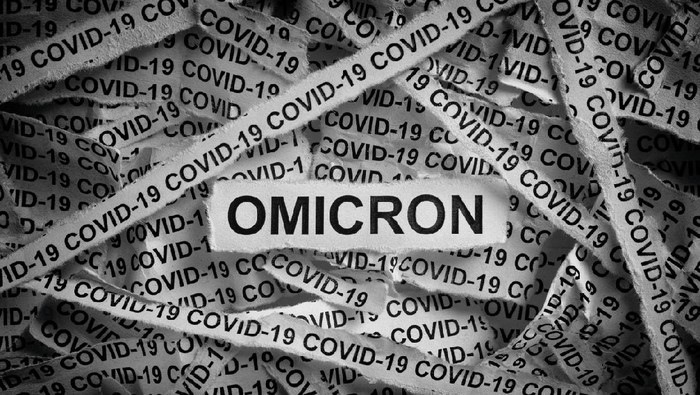Strips of newspaper with the words Omicron and Covid-19 typed on them. Omicron variant of COVID-19. Black and white. Close up.