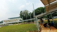 Panel surya di Taman Energi membentuk lingkaran, di tengah taman ada rerumputan.