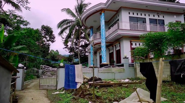 Ibra sempat mampir ke rumah seorang warga desa tersebut. Rumah berlantai dua itu memiliki pilar yang dihiasi motif langit berwarna biru. (Foto: YouTube/Jejak Bang Ibra)