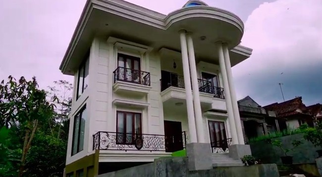 Seorang YouTuber bernama Ibra berbagi pengalamannya mengunjung sebuah desa bernama Jambu di Cilacap, Jawa Tengah. Desa tersebut penuh dengan rumah mewah. Salah satunya rumah ini yang bergaya klasik dan ditopang pilar besar bak istana. (Foto: YouTube/Jejak Bang Ibra)