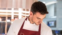 Saat di dapur, dirinya tak lupa menggunakan baju dan celemek khusus. Chef yang sering berbagi resep di Instagram ini sedang berpose bersama cake cokelat.