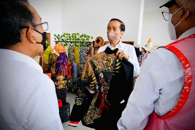 Di sela acara peresmian Bandar Udara Ngloram, Blora, Jawa Tengah, Jumat (17/12/2021), Presiden Joko Widodo atau Jokowi menyempatkan mampir melihat-melihat gerai UMKM di area lobi. Sebuah jaket model bomber mencuri perhatiannya. (Foto: Dok. BPMI Sekretariat Presiden)
