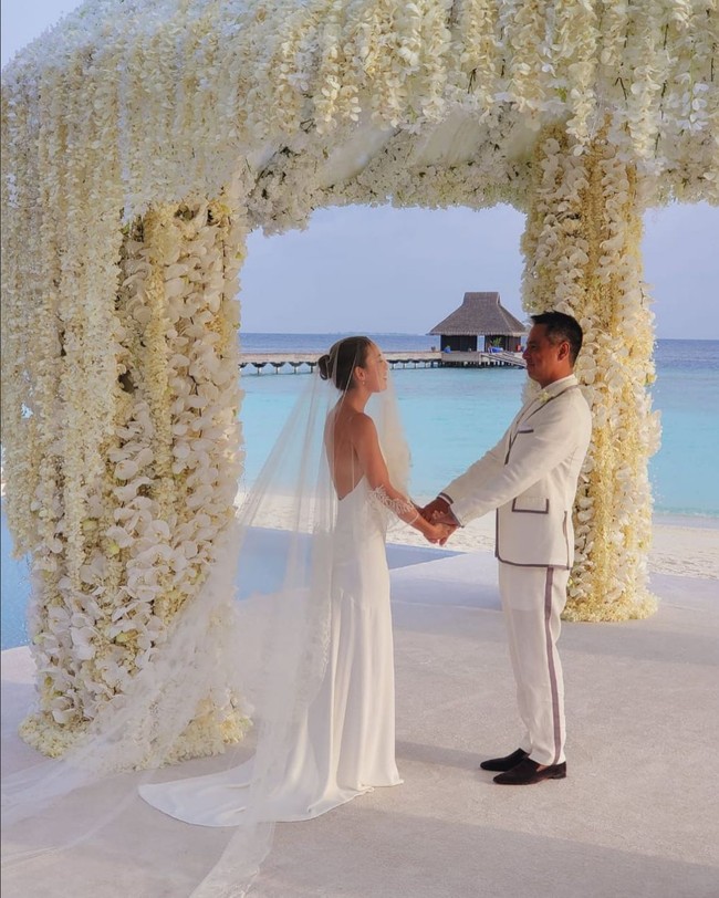 Simpel namun estetik, gaun pernikahan Julie Estelle cocok untuk kamu yang ingin menikah mengenakan gaun minimalis tapi tetap menonjolkan keanggunan. Saat menikah, aktris cantik ini mengenakan gaun backless karya Heaven Tanudiredja. Sementara veil panjang datang dari koleksi Biyan. Foto: Instagram