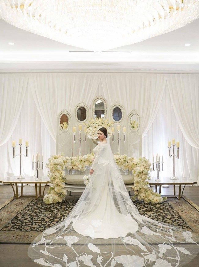 Gaun mewah untuk pemberkatan pernikahan Felicya Angelista merupakan karya desainer Yogie Pratama. Kaya detail dan cantik, gaun berpotongan mermaid ini juga tampak unik dengan veil berhias bordir bentuk floral. Foto: Instagram