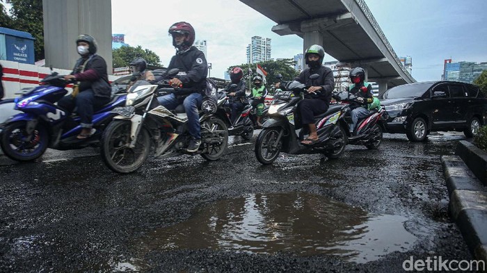 Jalan Rasuna Said Berlubang dan Tergenang Jalan Rasuna Said, Jakarta, tampak berlubang. Saat hujan turun, terjadi kubangan di jalan tersebut.