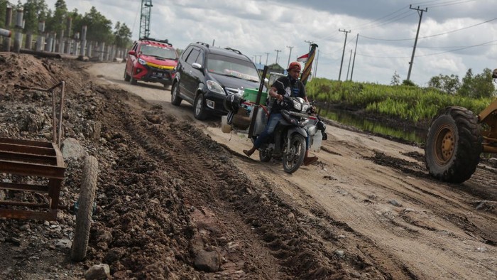 Kendaraan melintasi jalan rusak di Jalan Trans Kalimantan Bukit Rawi, Pulang Pisau, Kalimantan Tengah, Kamis (16/12/2021). Jalur nasional Kalimantan poros tengah yang merupakan penghubung Kota Palangkaraya dengan sejumlah kabupaten di Kalteng tersebut rusak dan berlubang setelah diterjang banjir luapan Sungai Kahayan dan Sungai Rungan selama tiga pekan. ANTARA FOTO/Makna Zaezar/rwa.