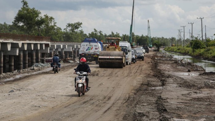 Kendaraan melintasi jalan rusak di Jalan Trans Kalimantan Bukit Rawi, Pulang Pisau, Kalimantan Tengah, Kamis (16/12/2021). Jalur nasional Kalimantan poros tengah yang merupakan penghubung Kota Palangkaraya dengan sejumlah kabupaten di Kalteng tersebut rusak dan berlubang setelah diterjang banjir luapan Sungai Kahayan dan Sungai Rungan selama tiga pekan. ANTARA FOTO/Makna Zaezar/rwa.