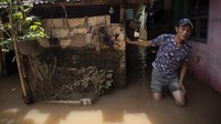 Warga melintasi banjir yang menggenangi permukiman di Pondok Pinang, Kebayoran Lama.