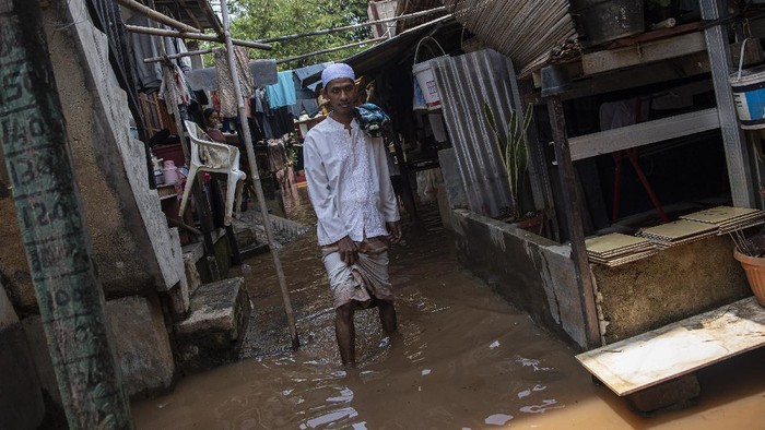 Warga melintasi banjir yang menggenangi permukiman di Pondok Pinang, Kebayoran Lama, Jakarta Selatan, Jumat (17/12/2021). Banjir sejak Kamis (16/12/2021) tengah malam tersebut disebabkan Kali Pesanggrahan yang ada di sekitar lokasi meluap. ANTARA FOTO/Sigid Kurniawan/tom.