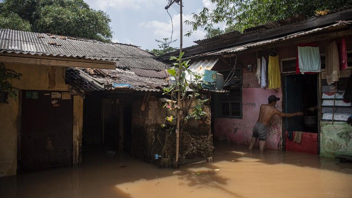 Kali Pesanggrahan Meluap, Warga Sekitar Kebanjiran Warga melintasi banjir yang menggenangi permukiman di Pondok Pinang, Kebayoran Lama, Jakarta Selatan, Jumat (17/12/2021). Banjir sejak Kamis (16/12/2021) tengah malam tersebut disebabkan Kali Pesanggrahan yang ada di sekitar lokasi meluap. ANTARA FOTO/Sigid Kurniawan/tom.