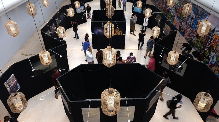 Pengunjung mengamati foto dalam pameran foto jurnalistik bertajuk 