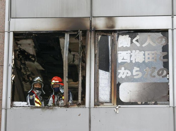 Firefighters stand on a floor at a building where a fire broke out in Osaka, western Japan Friday, Dec. 17, 2021. Japans NHK says a fire broke out in the building and dozens of people were feared dead. (Kyodo News via AP)