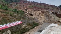 Tampak pula masih ada gundukan tanah dan tumpukan batu split di tengah badan jalan yang belum dilakukan betonisasi.