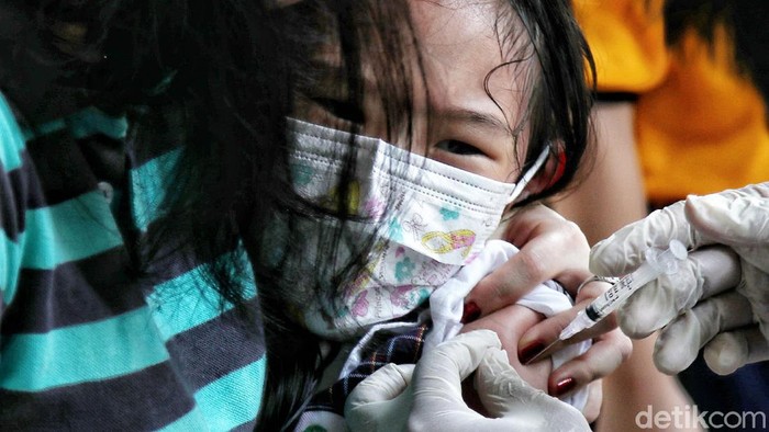 Ragam Ekspresi Anak-anak di Jakarta Utara yang Antusias Ikut Vaksinasi COVID Vaksinator memberi vaksin Sinovac dosis pertama kepada anak-anak di kawasan Perumahan Layar Permai, Pantai Indah Kapuk, Jakarta Utara, Jumat (17/12).