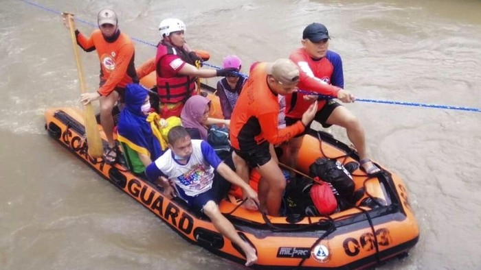 Saat Puluhan Ribu Warga Filipina Dievakuasi Akibat Badai Topan Rai Dalam foto yang dibagikan oleh Penjaga Pantai Filipina ini, tim penyelamat membantu warga di atas banjir yang disebabkan oleh Topan Rai saat mereka dievakuasi ke tempat yang lebih tinggi di Kota Cagayan de Oro, Filipina selatan, Kamis, 16 Desember 2021. Puluhan ribu orang terdampar dievakuasi ke tempat yang aman di Filipina selatan dan tengah ketika Topan Rai mendekati Kamis pada saat pihak berwenang memperingatkan masyarakat untuk menghindari kerumunan setelah infeksi pertama yang disebabkan oleh jenis virus corona dilaporkan di negara itu, kata para pejabat. (Penjaga Pantai Filipina melalui AP)