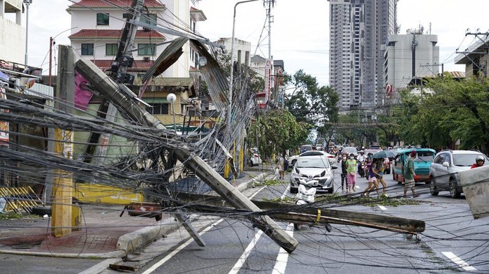 Warga menyelamatkan sisa-sisa rumah mereka yang rusak akibat Topan Rai di kota Cebu, Filipina tengah, Jumat, 17 Desember 2021. Topan dahsyat menghantam Filipina tenggara pada Kamis, menumbangkan pohon, merobek atap seng, dan merobohkan listrik. itu meledak di seluruh provinsi pulau di mana hampir 100.000 orang telah dievakuasi. (Foto AP/Jay Labra)