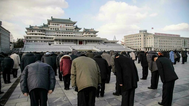 Warga Korut membungkukkan badan saat momen mengheningkan cipta selama tiga menit untuk memperingati meninggalnya Kim Jong-Il, ayah Kim Jong-Un People bow during a three-minute silence to mark the 10th death anniversary of North Korean leader Kim Jong Il (KIM Won Jin/AFP)