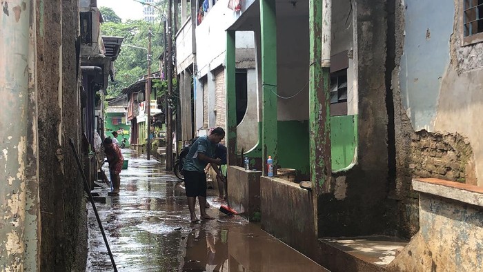 Warga Pondok Pinang bersih-bersih usai kebanjiran akibat luapan kali.