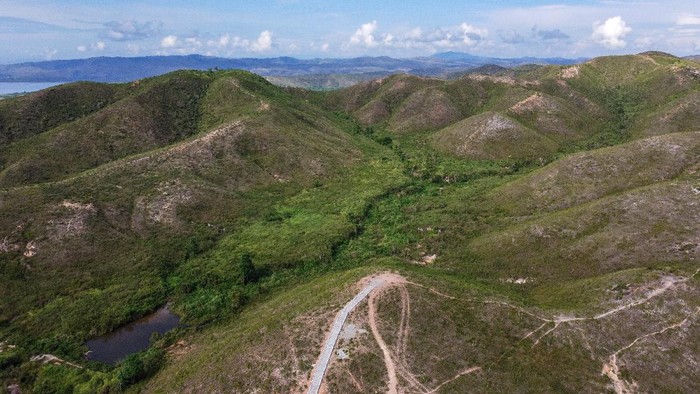 Sejumlah warga melintasi anak tangga di Bukit Tatanggo di Pulau Buru, Provinsi Maluku, Sabtu (18/12/2021). Bukit Tatanggo merupakan salah satu objek wisata yang berjarak sekira empat kilometer dari pusat Kota Namle, Ibu Kota Kabupaten Buru, yang menawarkan pemandangan perbukitan yang penuh tanaman minyak kayu putih. ANTARA FOTO/FB Anggoro.