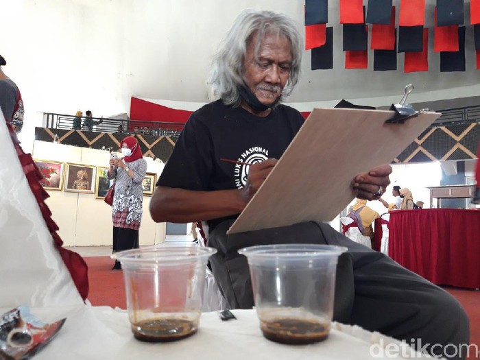 Darto, melukis sketsa wajah menggunakan media kopi, Sabtu (18/12/2021).