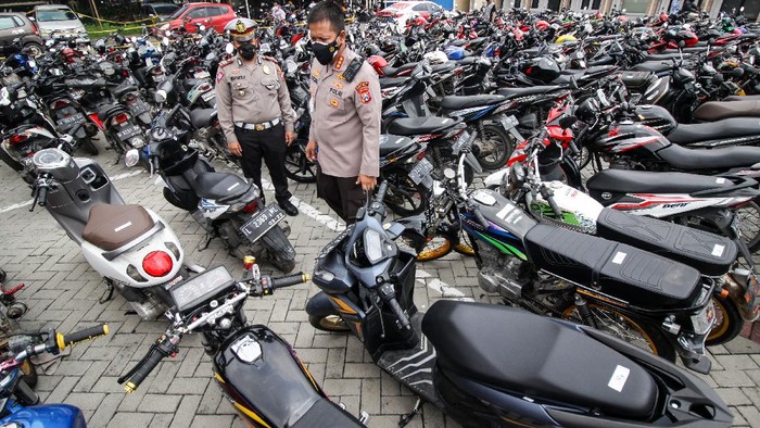 HASIL RAZIA BALAP LIAR Petugas menyaksikan pemotongan knalpot yang tidak standar atau