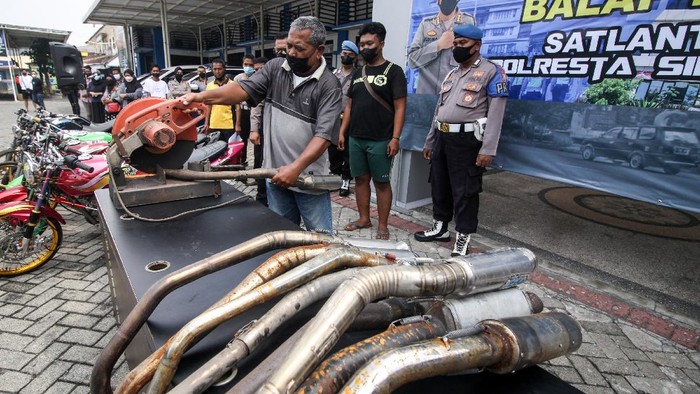 Petugas menyaksikan pemotongan knalpot yang tidak standar atau 