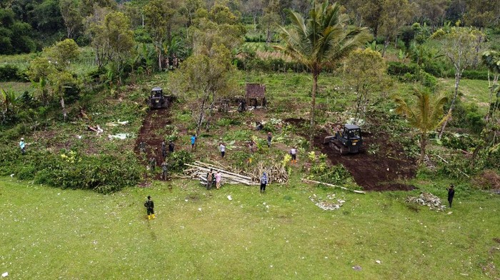 Prajurit TNI  membersihkan kebun kopi milik Perhutani di Desa Sumber Mujur, Candipuro, Lumajang, Jawa Timur, Sabtu (18/12/2021). Pemerintah menyiapkan lahan seluas 81 hektare milik Perhutani sebagai tempat hunian sementara korban erupsi Gunung Semeru. ANTARA FOTO/Budi Candra Setya/nym.