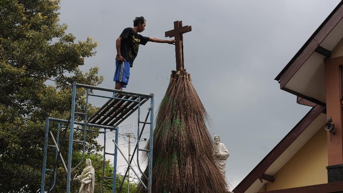 POHON NATAL DARI SAPU LIDI Petugas gereja memasang kayu salib saat membuat pohon Natal dari sapu lidi di Gereja Katolik Santa Perawan Maria Bunda Kristus, Wedi, Klaten, Jawa Tengah, Sabtu (18/12/2021). Pohon Natal yang terbuat dari susunan sapu lidi itu sebagai lambang kekompakan dan persatuan gerak langkah umat Katolik, sehingga menjadi kuat, rukun, tangguh dan berbuah antarsesama manusia dalam menyambut hari besar kelahiran Yesus Kristus. ANTARA FOTO/Aloysius Jarot Nugroho/nym.