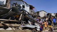 Usai angin topan melanda, tak sedikit warga yang kembali ke rumah mereka yang telah porak poranda disapu topan untuk menyelamatkan barang-barang berharga. AP Photo/Jay Labra. 
