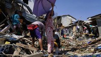 Warga mencari dan mengumpulkan barang-barang yang masih dapat diselamatkan dari rumah mereka yang hancur dihantam topan. AP Photo/Jay Labra. 