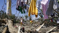 Tampak seorang warga beraktivitas di antara sisa-sisa kerusakan akibat Topan Rai di kawasan Talisay, Provinsi Cebu, Filipina. AP Photo/Jay Labra. 