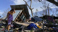 Seorang warga berdiri di depan rumahnya yang rusak berat akibat dihantam Angin Topan Super Rai di kawasan Talisay, Provinsi Cebu, Filipina, Sabtu (18/12/2021) waktu setempat. AP Photo/Jay Labra.