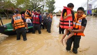Petugas penyelamat menggendong seorang anak yang terdampak banjir di kawasan Hulu Langat, Malaysia, Minggu (19/12/2021). AP Photo/Vincent Thian.