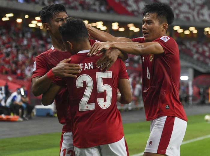 Indonesias Irfan Samaling Kumi (C#25) celebrates after scoring his first goal against Malaysia during the AFF Suzuki Cup 2020 Group B football match between Malaysia and Indonesia at the National Stadium in Singapore on December 19, 2021. (Photo by Roslan RAHMAN / AFP)