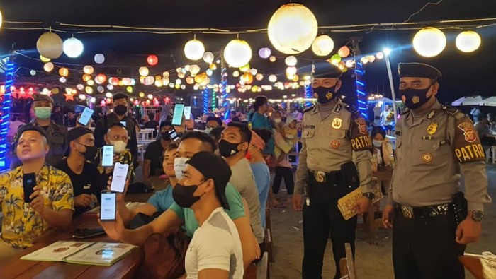 Wisatawan yang menghabiskan malam Minggu di kawasan Kampung Turis pantai Pangandaran menunjukan sertifikat vaksinasi.
