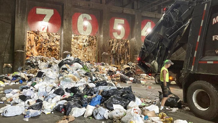 Amerika Serikat Jadi Negara Penghasil Sampah Terbesar di Dunia Seorang pekerja membongkar truk sampah di ecomaine, Selasa, 22 Juni 2021, di Portland, Maine. Konverter limbah menjadi energi seperti ecomaine melihat peningkatan jumlah sampah yang mereka kumpulkan untuk menghasilkan listrik saat pandemi virus corona mereda di AS. Fasilitas ini membakar sampah untuk menghasilkan listrik. Pemerhati lingkungan dan pendukung energi terbarukan sedang memperdebatkan apakah menciptakan lebih banyak energi dengan membakar kelebihan limbah adalah ide yang aman. (Foto AP/Patrick Whittle)