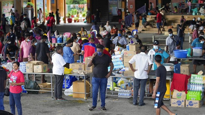 Warga mengarungi jalan yang banjir di Shah Alam, di pinggiran Kuala Lumpur, Malaysia, Senin, 20 Desember 2021. Layanan penyelamatan pada Senin bekerja untuk membebaskan ribuan orang yang terjebak banjir terparah Malaysia dalam beberapa tahun setelah hujan lebat berhenti menyusul lebih banyak lagi. dari tiga hari hujan deras di ibu kota dan di seluruh negeri. (Foto AP/Vincent Thian)