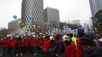 Ribuan pengunjuk rasa berdemonstrasi di pusat Brussel untuk ketiga kalinya menentang pembatasan COVID-19 yang diberlakukan oleh pemerintah Belgia untuk melawan lonjakan infeksi dan munculnya varian omicron yang mengkhawatirkan. Tanda di sebelah kiri bertuliskan Jauhi anak-anak kita, dan tanda di sebelah kanan bertuliskan Bebas dari suntikan. AP/Olivier Matthys