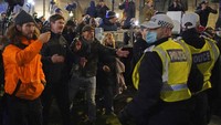 Pengunjuk rasa vaksinasi anti-COVID-19 bereaksi dengan polisi selama protes di Whitehall, di London, Sabtu, (18/12/2021). Ratusan orang memprotes di London Sabtu, memblokir lalu lintas saat mereka berbaris dengan membawa spanduk bertuliskan slogan-slogan seperti “Paspor vaksin membunuh kebebasan kita” dan “Jangan patuhi.” AP/Dominic Lipinski