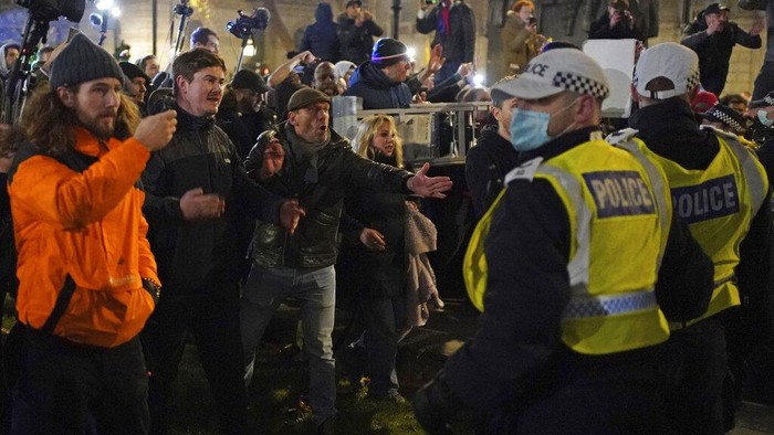 Demo COVID Inggris Pengunjuk rasa vaksinasi anti-COVID-19 bereaksi dengan polisi selama protes di Whitehall, di London, Sabtu, 18 Desember 2021. Ratusan orang memprotes di London Sabtu, memblokir lalu lintas saat mereka berbaris dengan membawa spanduk bertuliskan slogan-slogan seperti “Paspor vaksin membunuh kebebasan kita” dan “Jangan patuhi.” (Dominic Lipinski//PA melalui AP)