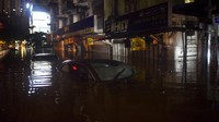 Sebuah mobil terendam di salah satu ruas jalan di Kuala Lumpur. AFP/Arif Kartono.