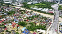 Hujan deras sejak Jumat (18/12) telah menyebabkan sungai meluap, menenggelamkan banyak daerah perkotaan dan memutus jalan-jalan utama, membuat ribuan pengendara telantar. Chan Yoke Poh/Lion Club International 308B1 via AP.