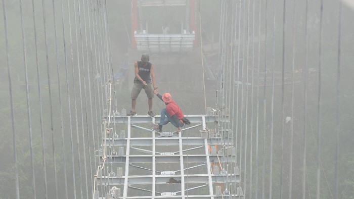 Dusun Terpencil di Lereng Merapi Bakal Punya Jembatan Gantung Sejumlah pekerja membawa kerangka besi saat membangun jembatan gantung di lereng Gunung Merapi, Tegalmulyo, Kemalang, Klaten, Jawa Tengah, Sabtu (18/12/2021). Pembangunan jembatan gantung tersebut diharapkan dapat mempermudah akses bagi warga yang tinggal di kampung terpencil Girpasang serta mendukung pengembangan pariwisata di kawasan tersebut. ANTARA FOTO/Aloysius Jarot Nugroho/foc.