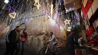 Orang-orang berjalan di Kota Tua Damaskus, Suriah, yang didekorasi untuk liburan Natal mendatang, Selasa, (14/12/2021). (AP Photo/Omar Sanadiki)