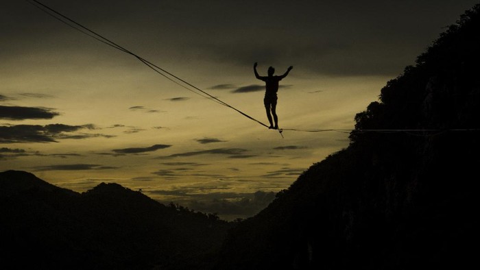 Pegiat olahraga ekstrem berjalan di atas tali webbing pada kegiatan Bandung Highlines Festival di Tebing Hawu, Kabupaten Bandung Barat, Sabtu (18/12/2021). Kegiatan tersebut menjadi ajang berkumpulnya para pegiat olahraga 