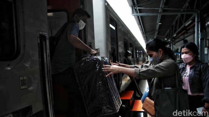 Ratusan penumpang bersiap menaiki kereta api jarak jauh di kawasan Stasiun Pasar Senen, Jakarta Pusat, Senin (20/12).